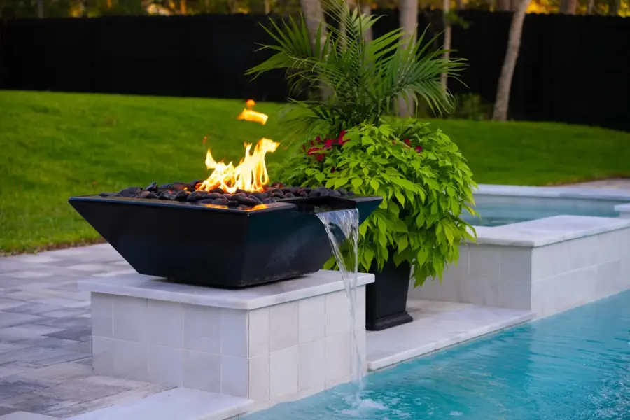 Fire water bowl at the edge of a modern pool, enhancing the outdoor space’s luxurious feel