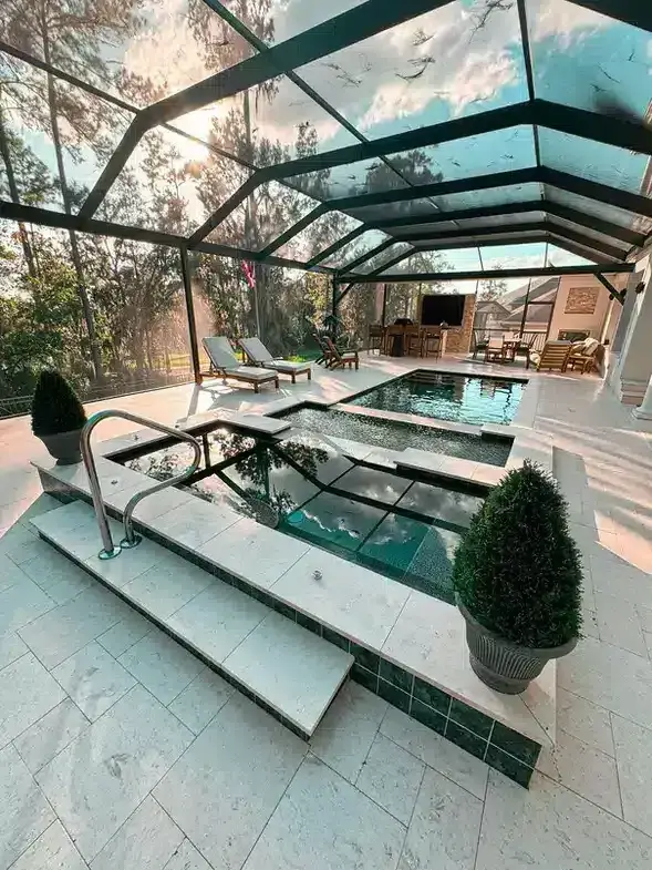 Screen-enclosed pool with a raised spa, topiary planters and an outdoor kitchen