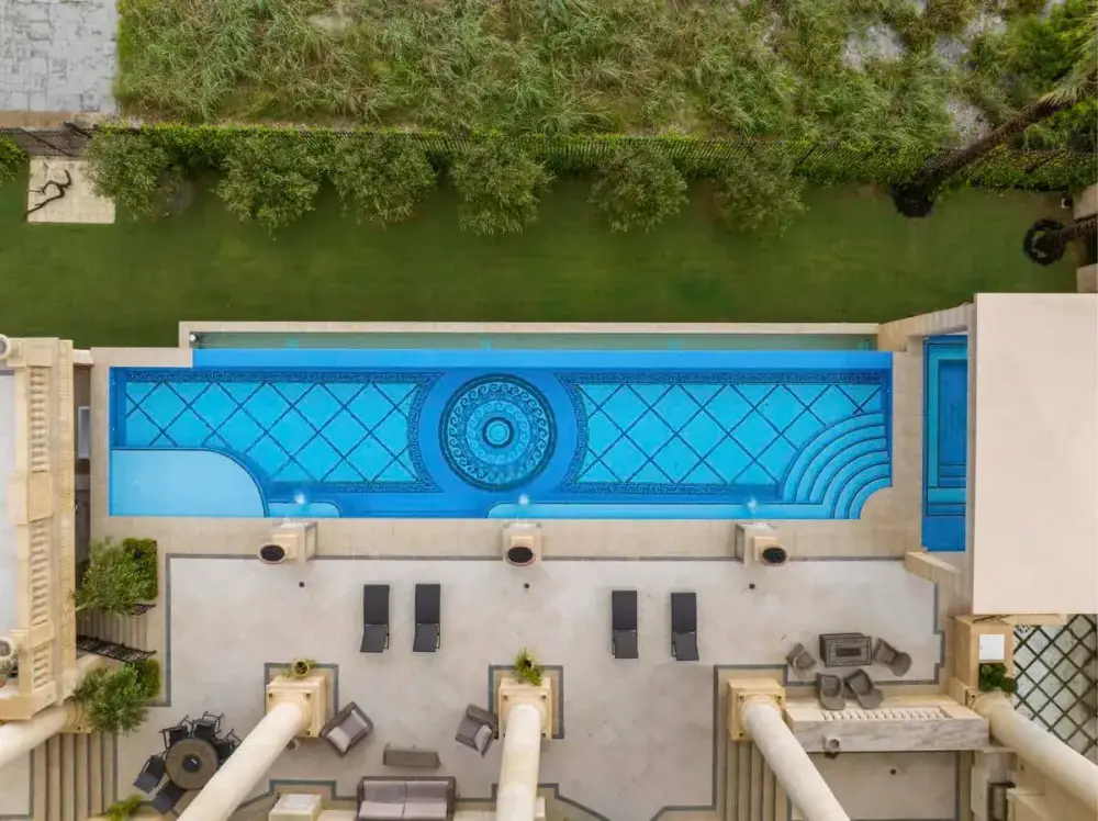 Aerial view of a custom pool in Tampa with intricate tile work and spacious lounge areas ideal for backyard relaxation