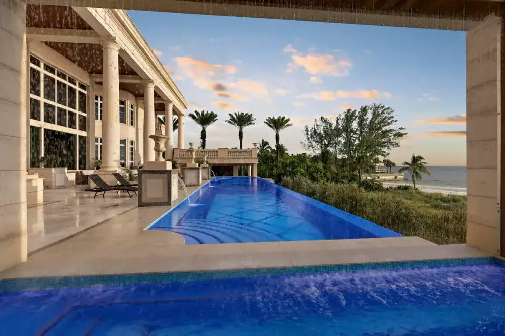 Luxury pool in Tampa with a sheltered lounge area and lush landscaping, offering a private and relaxing outdoor escape.
