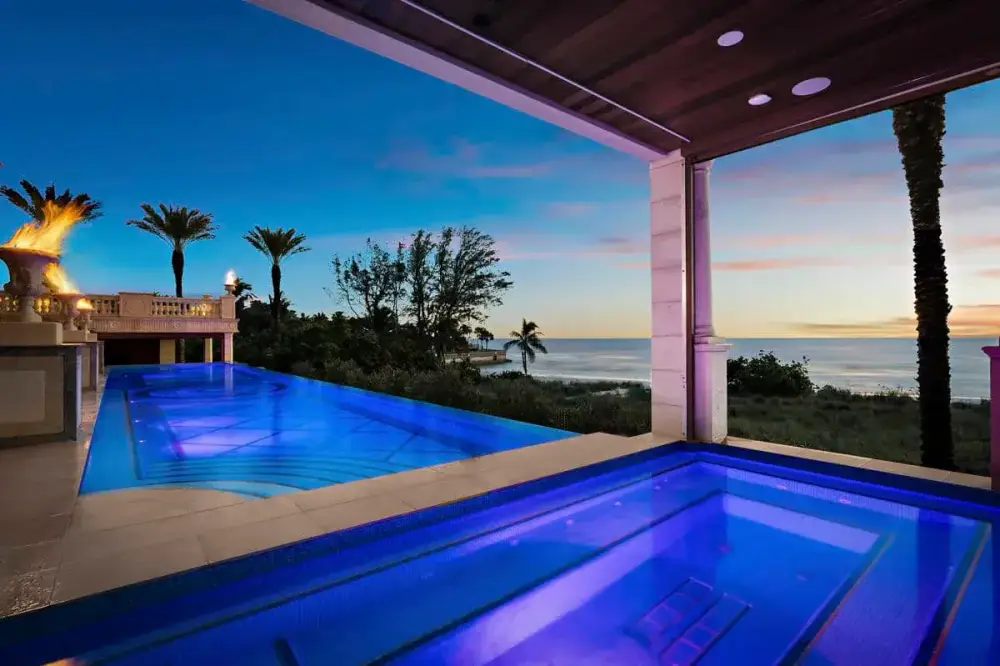 Luxury pool in Tampa with integrated lighting and a sheltered lounge area, creating an inviting nighttime ambiance.