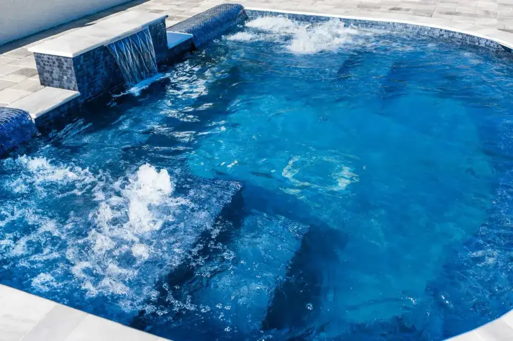 Sleek and Stylish Pool with Bubbling Jets and Spillover Spa